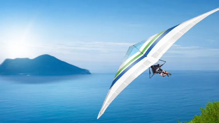 Paraglider flying over the sea