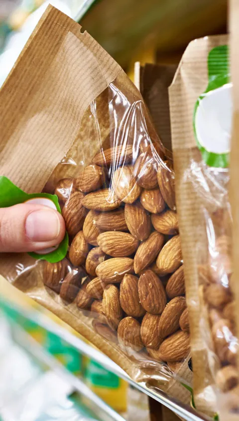hand grabbing pack of almond