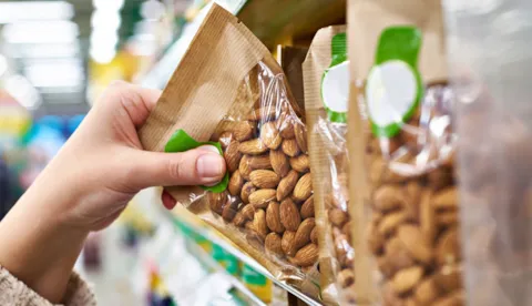 hand grabbing almond from shelf